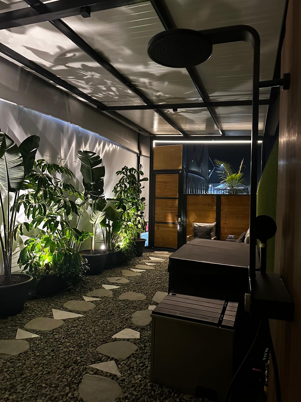 Stone path through the planted garden courtyard at night, with soft uplighting